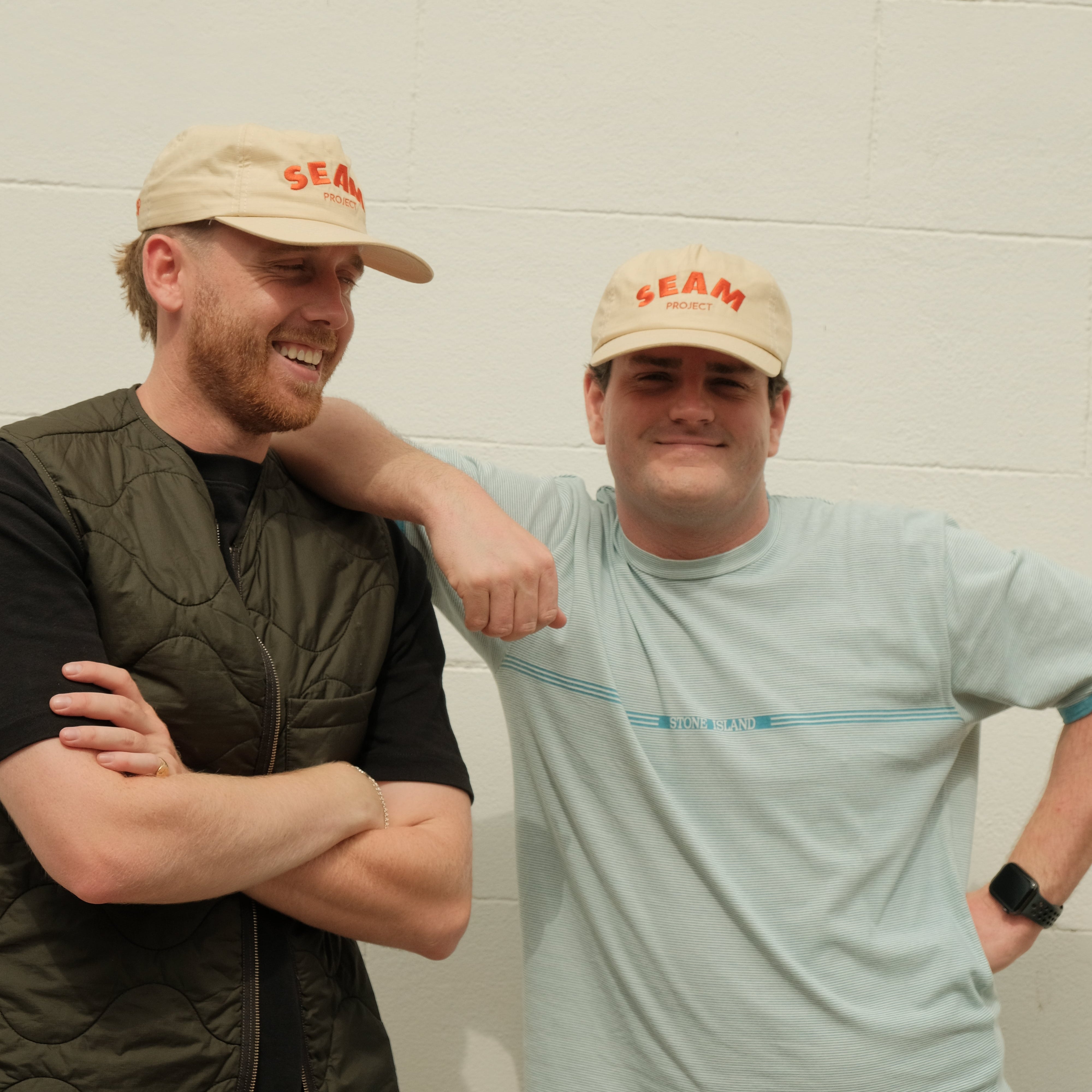 Two men wearing visors against a plain background